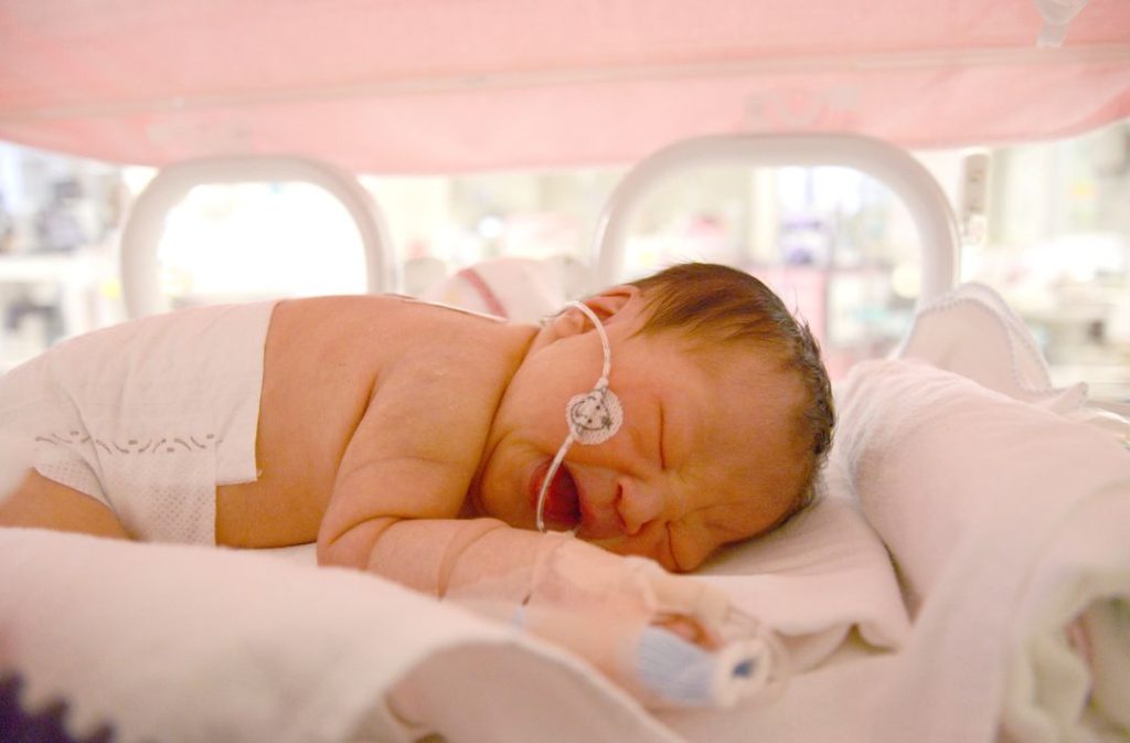 Birth mother bonding with her baby in the NICU