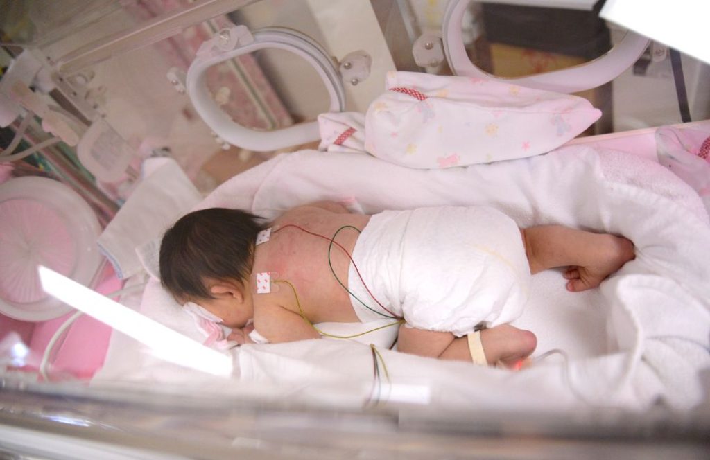 Birth mother bonding with her baby in the NICU