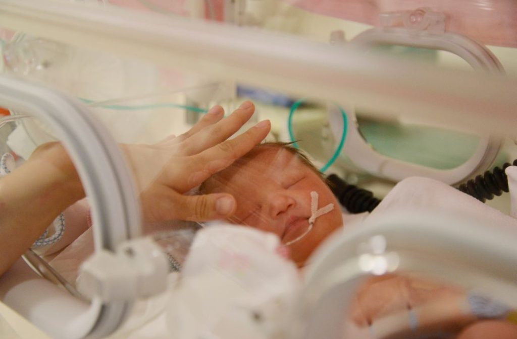 Birth mother bonding with her baby in the NICU