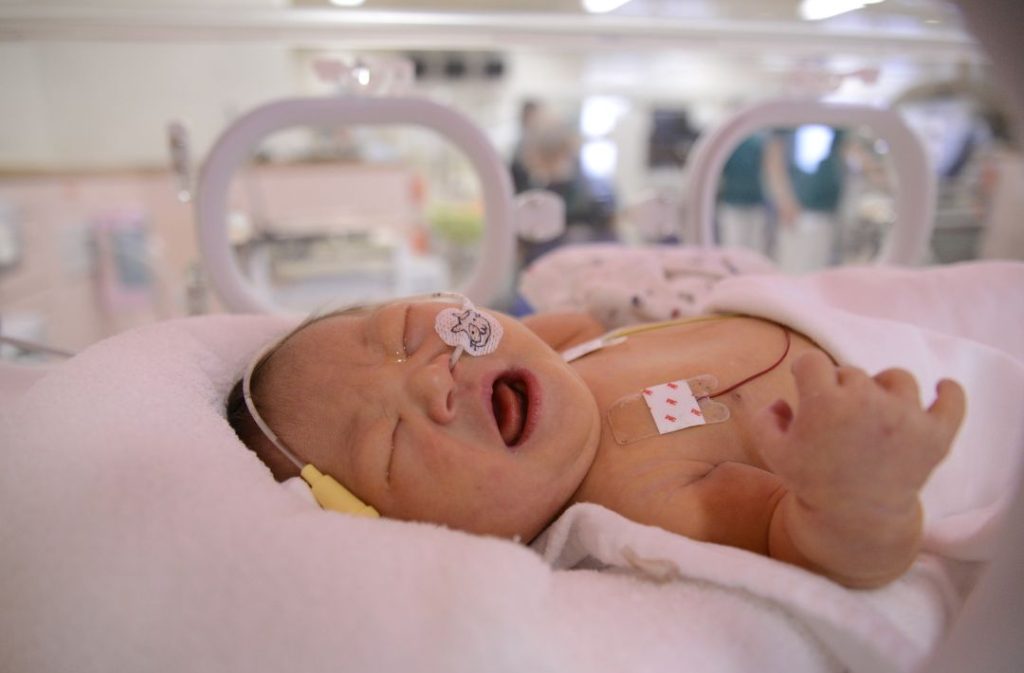 Birth mother bonding with her baby in the NICU