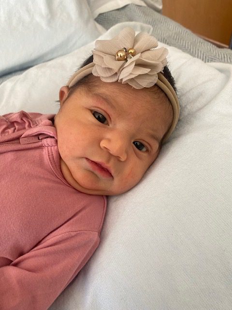 The baby girl in a pink outfit and headband