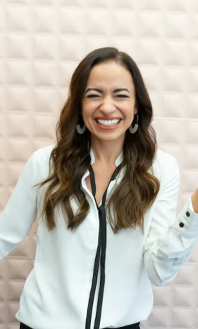 Cherie laughing in front of a white tiled wall