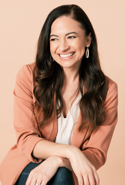 Cherie Hoeger smiling in a coral blazer